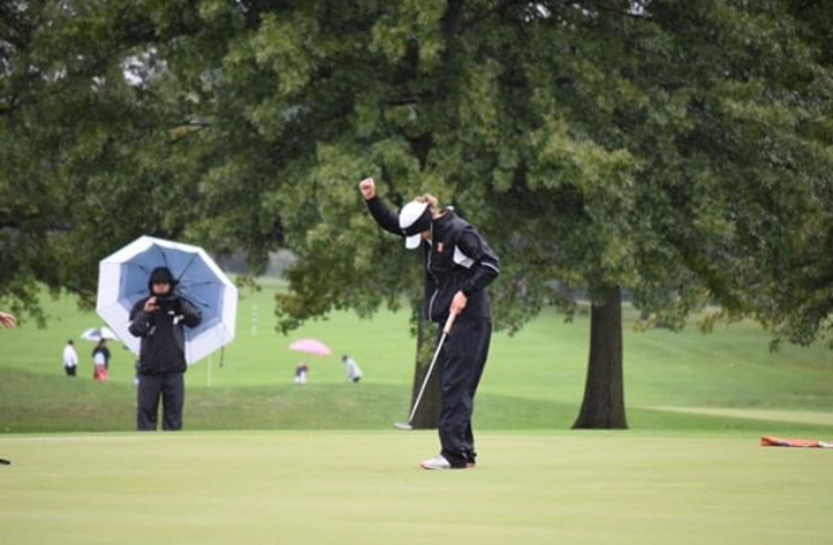 Senior Allison Enchelmayer pumps her fist in celebration after completing a putt during a rainy day at the State competition. 