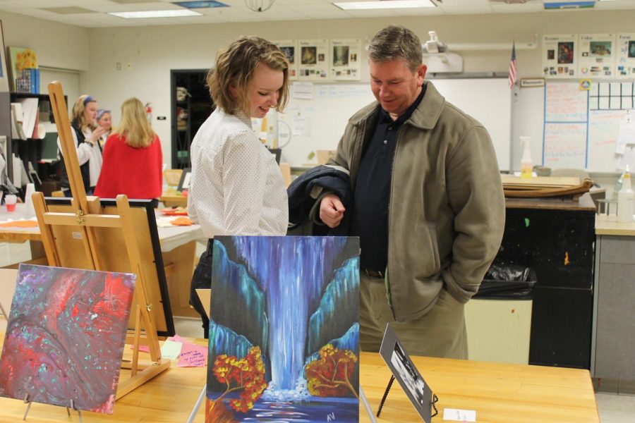 Anabelle Chinski (12) shows her artwork to her father
