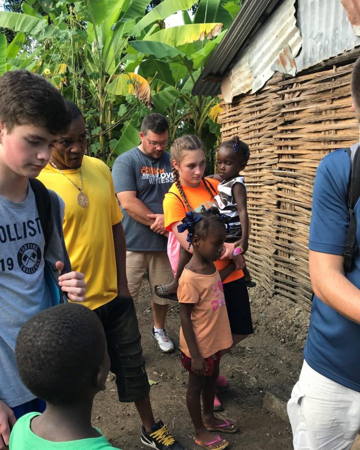 Regan Smith holds a child as a Haitian family is being prayed for.