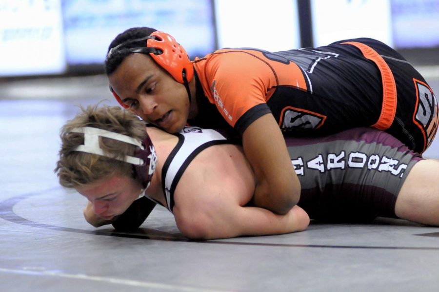 Josh Delgadillo ('19) attempts to transition into a half nelson to pin his opponent from Champaign Central.