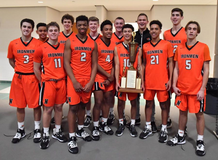 The Boys Basketball team poses with the Intercity championship trophy after their 63-60 win at the Shirk Center on Monday, December 2nd.