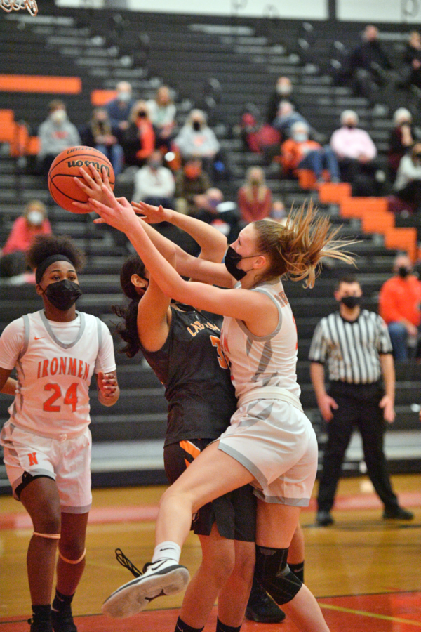 Lauren Hlava (’23) fights for the ball in a game against Peoria Manual last season. Being up in peoples faces and bothering them is the goal of the Lady Irons defense, Creasey said.