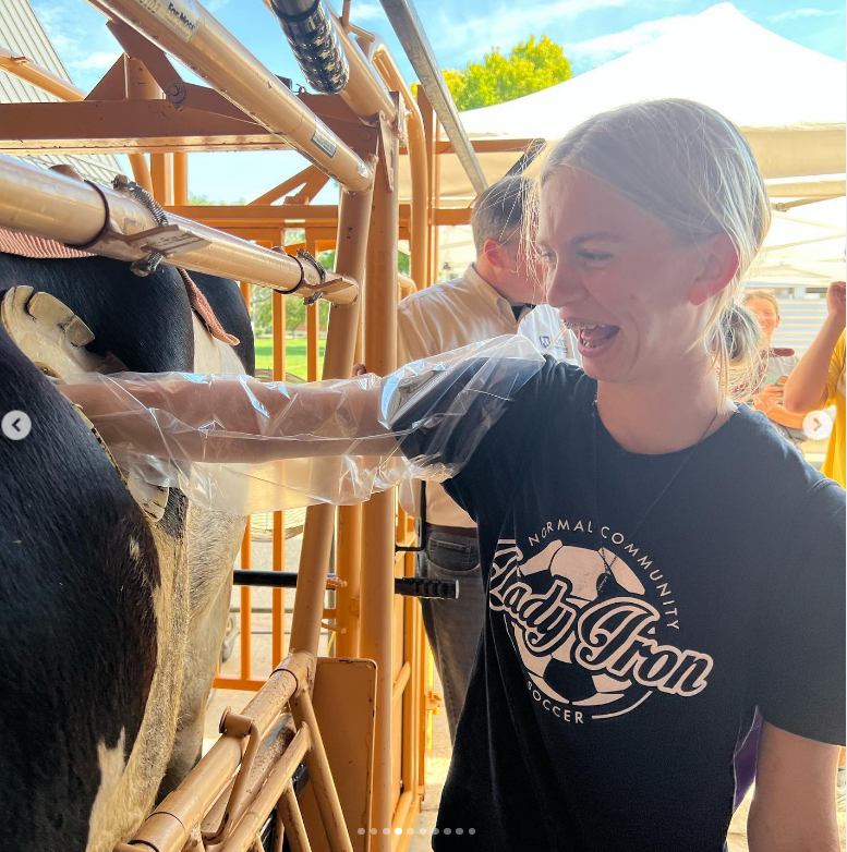 Junior Mary Baker places her hand into a fistulated cow, a  cow surgically fitted with a cannula. The  cannula acts as a porthole-like device that allows access to the rumen of a cow, to perform research and analysis of the digestive system.
