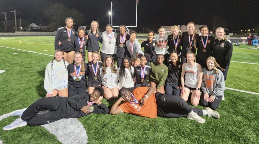 The girls track & field team pose for a photo after winning programs third straight Big 12 Conference title at Champaign Central High School May 5.