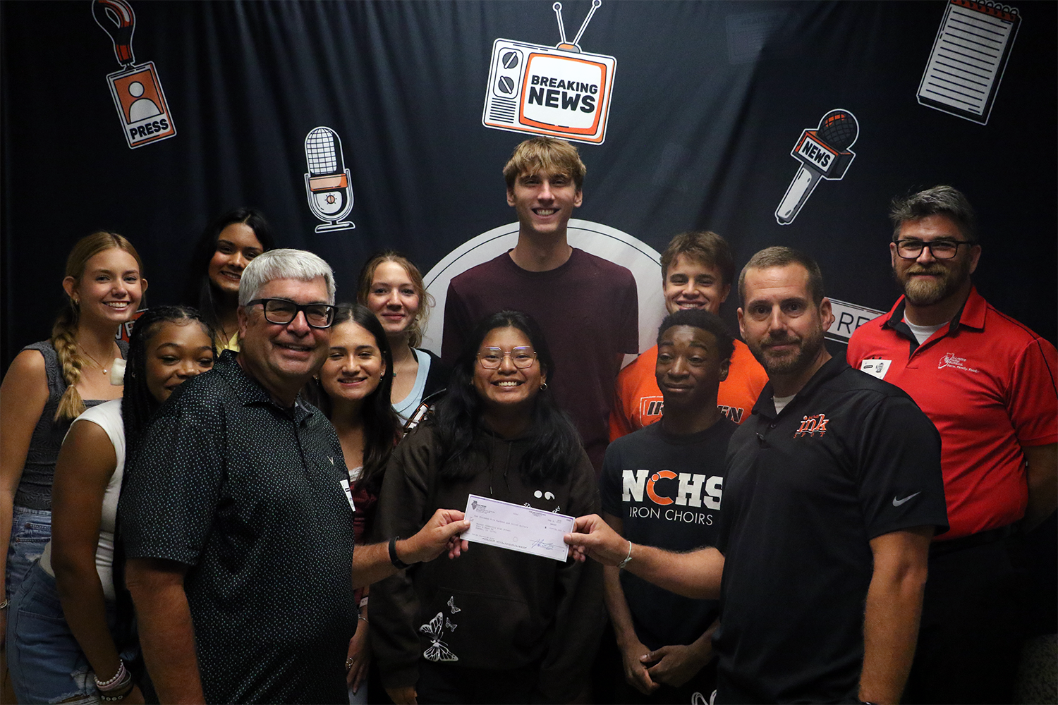 Illinois Press Foundation executive director Jeff Rogers presents the Journalism 2 students with a $5000 check to purchase a new telephoto camera lens.