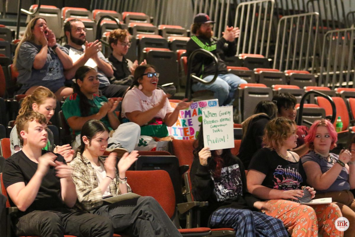 Supporters applaud as Community alumni Jolene Custer speaks in support of the educator.